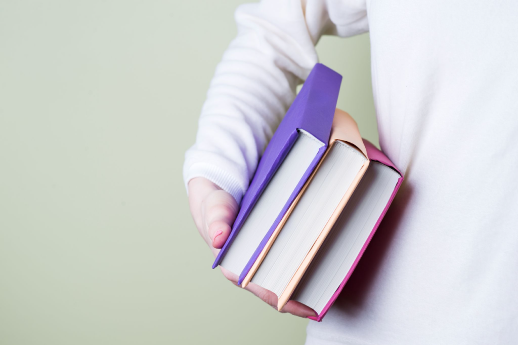 What MCAT Prep Really Costs & How to Prep Well Without Overpaying 1 A premed student holding books that were bought for MCAT preparation